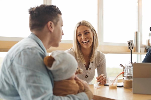 Photo of Guy and Allana, smiling, at a cafe